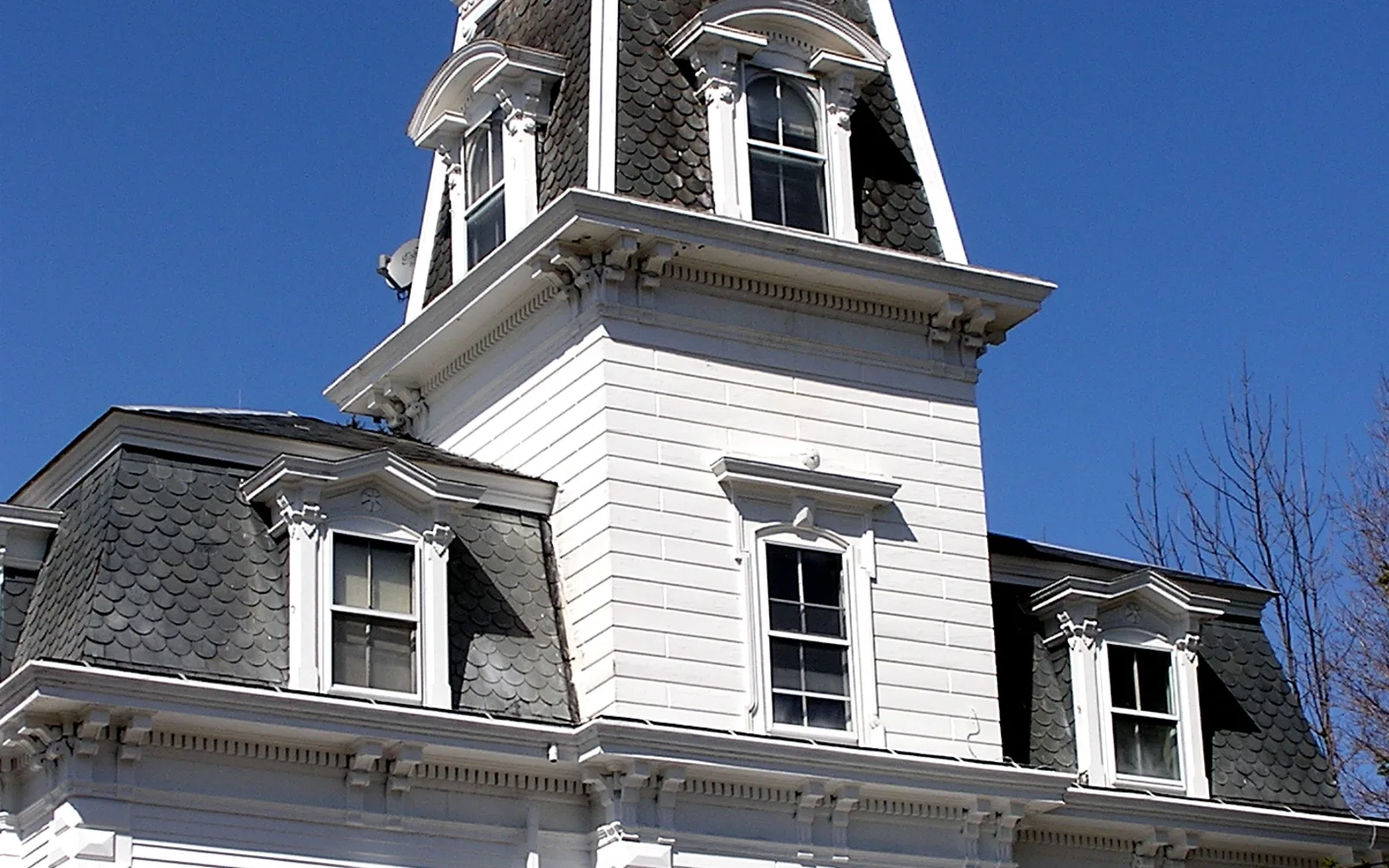 A large Victorian house with white exterior and architectural details